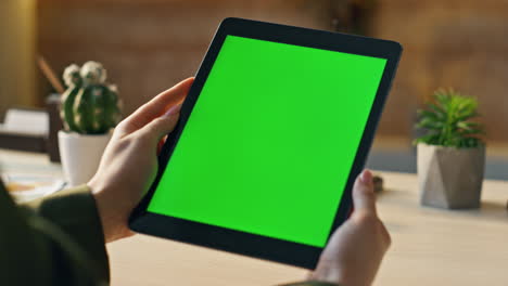 manager watching chroma key tablet at desk close up. hands holding green screen.