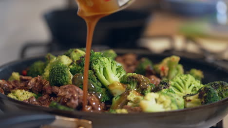 adding the sauce to the beef and broccoli stir fry meal - slow motion