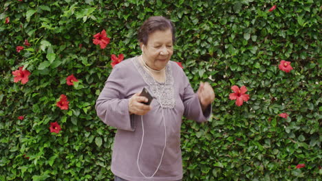 Retrato-De-Una-Elegante-Anciana-Bailando-Usando-Auriculares-Escuchando-Música-Disfrutando-De-Diversión-Celebrando-Un-Feliz-Estilo-De-Vida-De-Jubilación