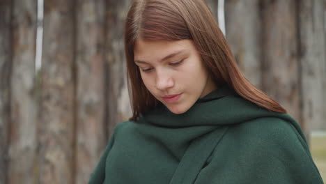 girl in medieval clothes reads note on piece of parchment