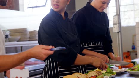 gerente dando órdenes al chef en la cocina comercial 4k