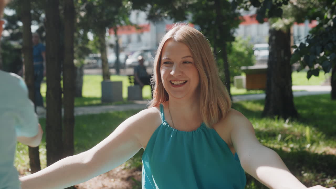 Geteilter Familienmoment. Glückliche Familie tauscht Blätter im Park. Mutter und Kind teilen einen fröhlichen Blättertausch im Freien. Eine herzliche Familienszene, festgehalten an einem friedlichen Wochenendnachmittag im Schatten.