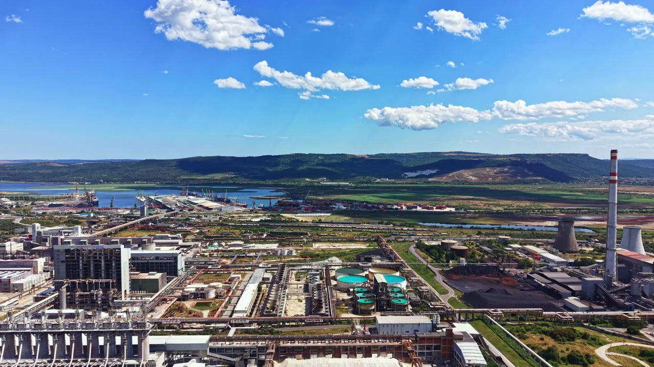 Centrale elettrica e area industriale vicino al fiume sotto un cielo sereno.