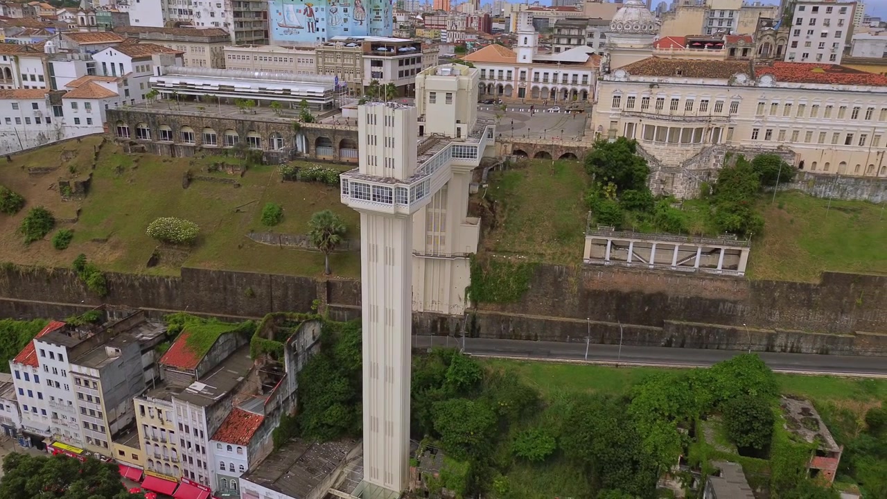 Ripresa fluida con drone in orbita attorno all'iconica struttura dell'Elevador Lacerda che collega la città alta e la città bassa a Salvador Bahia, Brasile.