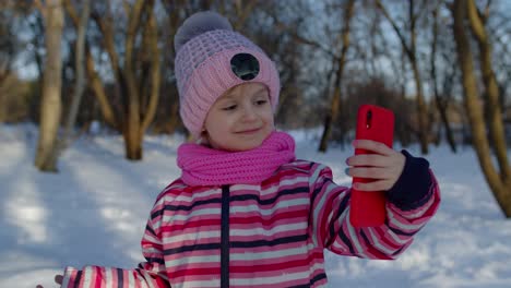 Children-kid-blogger-waving-hello,-making-video-call,-online-stream-on-social-media-in-winter-park