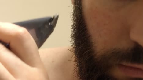 man’s facial hair trimming with an electric groomer