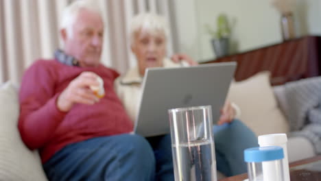 senior caucasian couple using laptop for online doctor consultation at home, slow motion