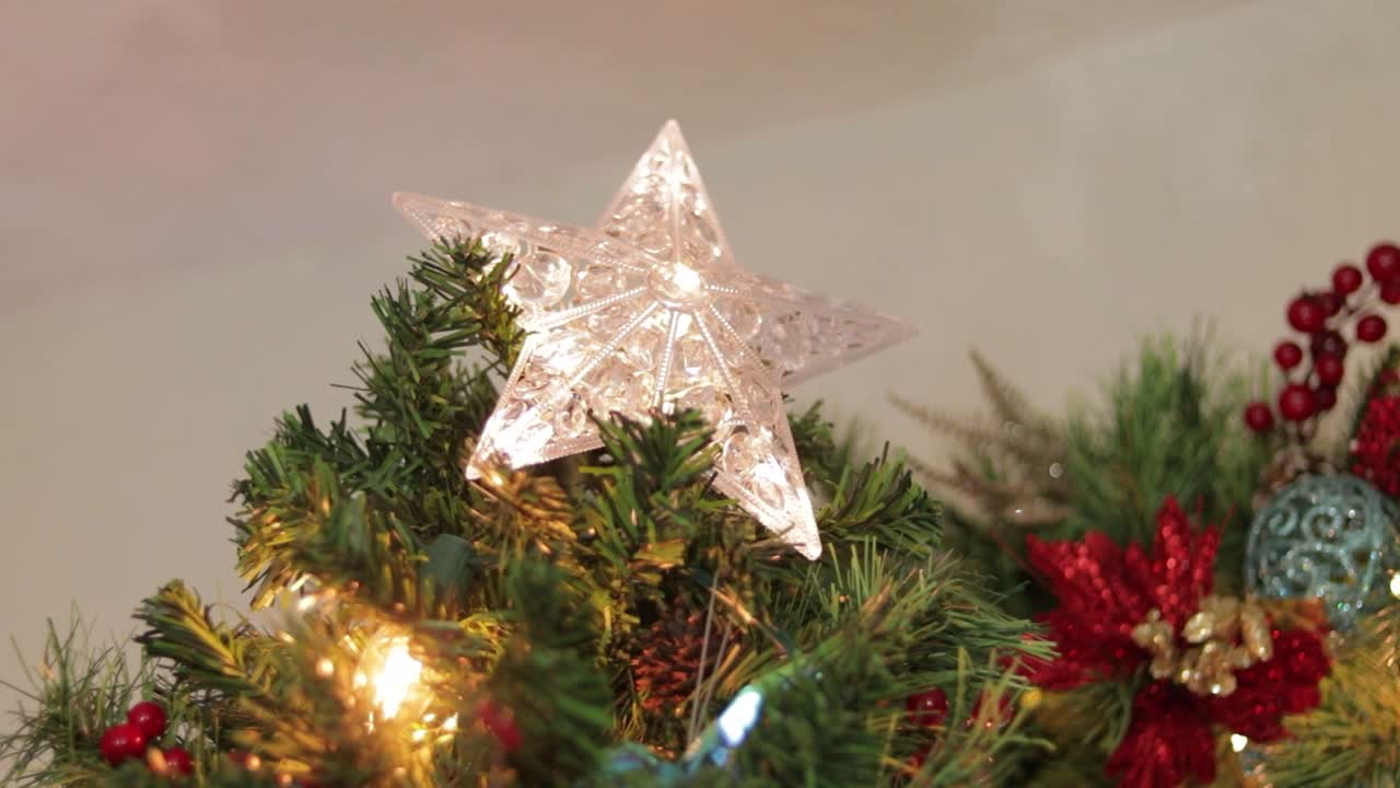 colocando descuidadamente la decoración de estrellas led parpadeantes en la parte superior del árbol de navidad