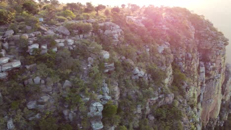 Aerial-orbit-around-large-rock-cliff-Three-Sister-Landmark,-Drankensburg-Mountains,-South-Africa