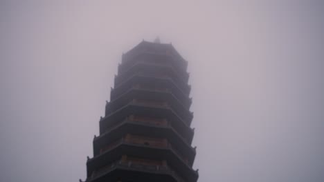 top exterior facade of bai dinh pagoda in ninh binh province of vietnam during misty morning. - low angle shot