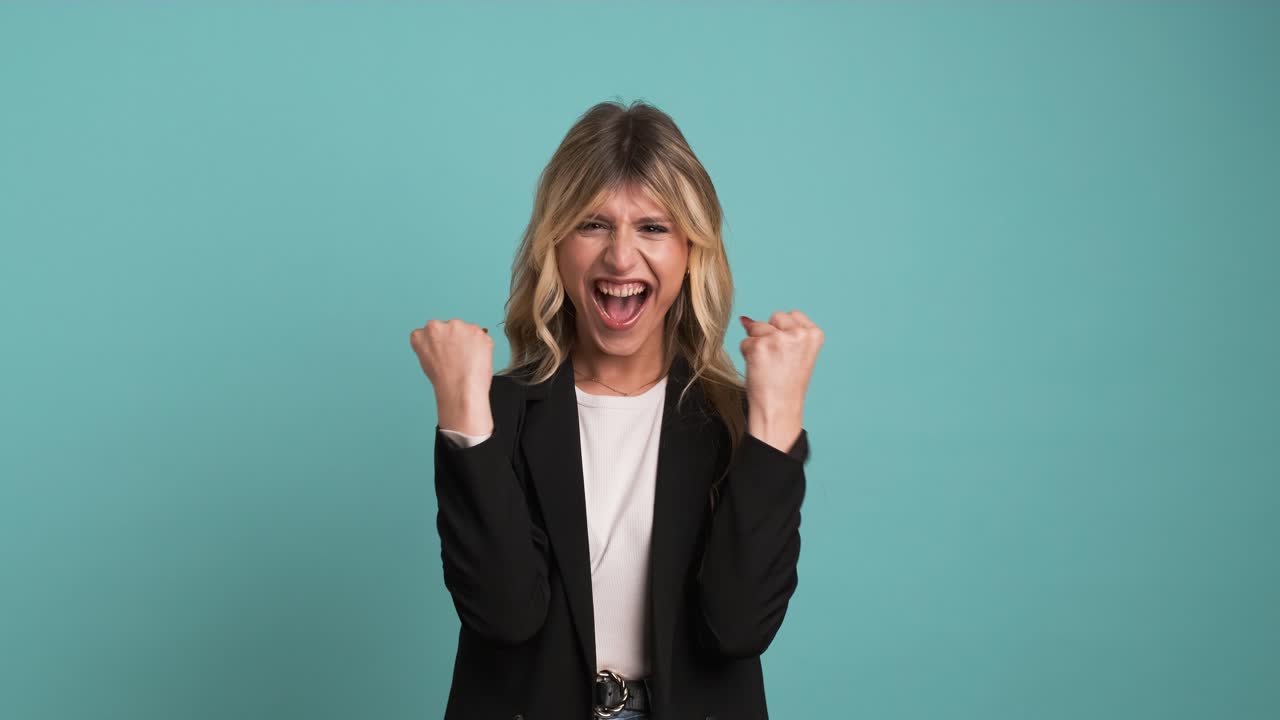 Successful transgender businesswoman with clenched fists celebrating victory