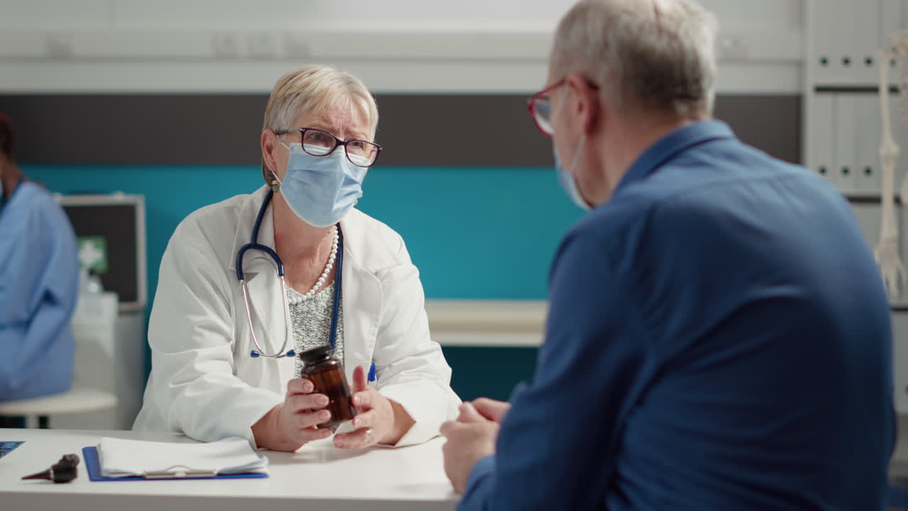 Senior doctor giving bottle of pills as prescription medicine