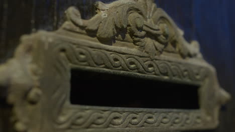 close-up of an ornate antique mailbox slot