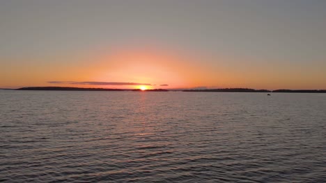 Drohne-Fliegt-Schnell-über-Wasser-Und-Sonnenuntergang