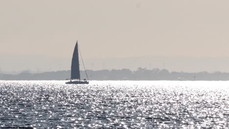 a sailboat sailing on a shimmering ocean