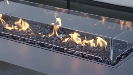 static shot of an integrated table fireplace burning outside providing heat