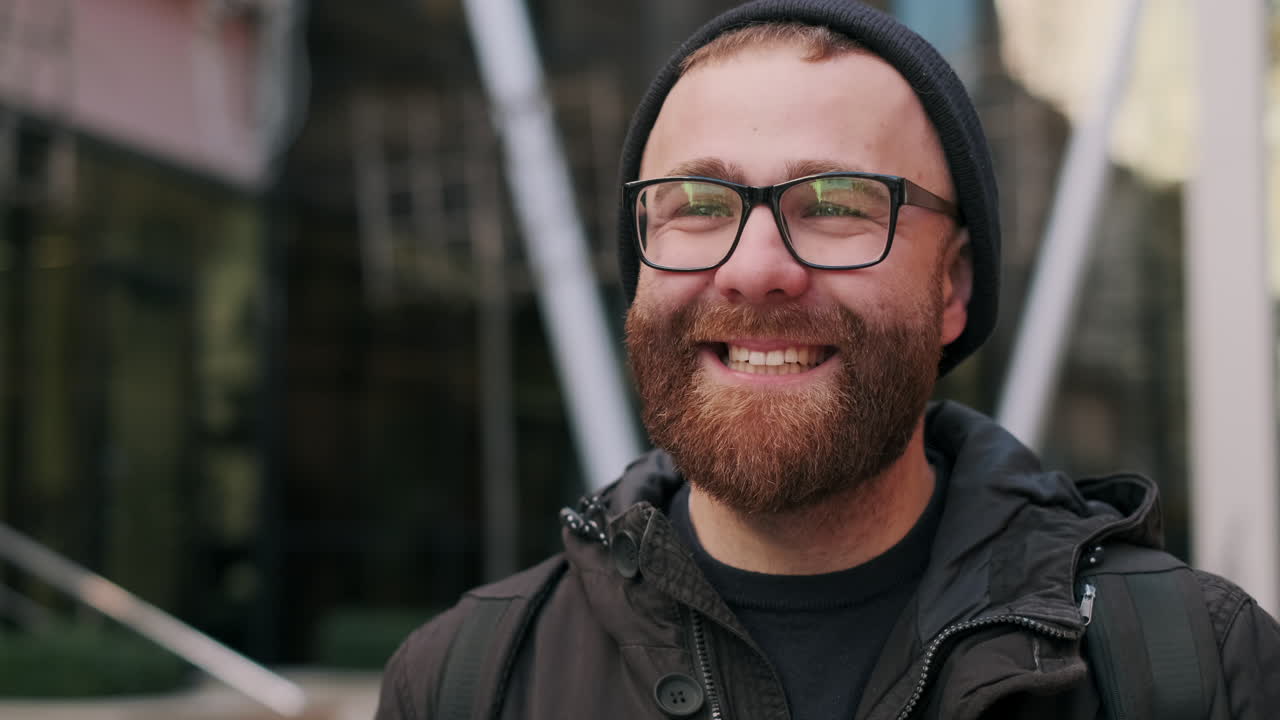 Portrait of a Happy Bearded Man with Glasses and Beanie in an Urban Setting