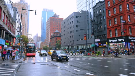 rainy day in modern new york, usa. people stand at the crossroads and cars run by the roads