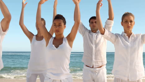 Group-of-people-practicing-yoga-on-the-beach