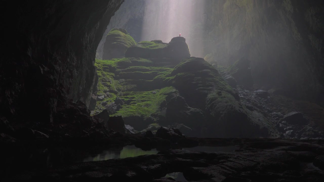 column of light shining on a person inside a big cave