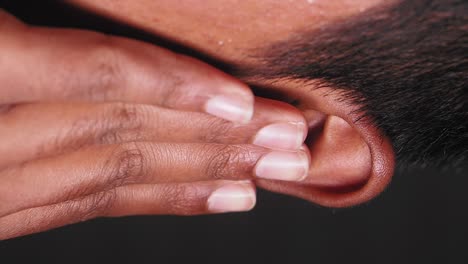 man touching his ear in pain