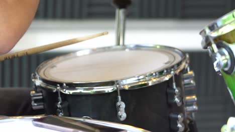 drummer playing drums with a wooden stick