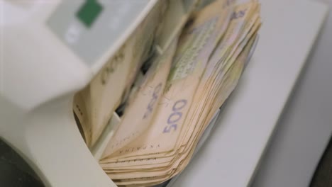 stack of ukrainian hryvnia in a bill counter machine