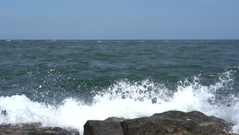 the waves from the ocean breaking over the rocks on the shore