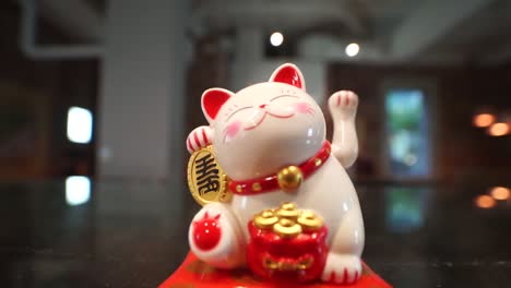 japanese waving lucky fortune cat - maneki-neko - beckoning cat displayed at store front