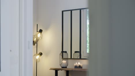 an entrance hall of a house with its furniture, mirror, and candles