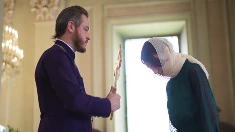 priest holding holy cross and blessing