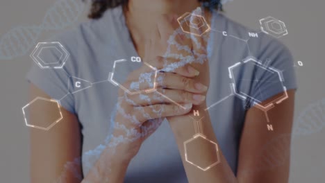 animación de diagramas de cadenas de adn sobre la sección media de una mujer biracial que se sostiene de la mano