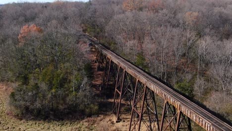 Tight-Aerial-Shot-Of-Train-Tracks-Running-off-the-Pope-Lick-Trestle-and-into-the-Woods-in-Louisville-Kentucky