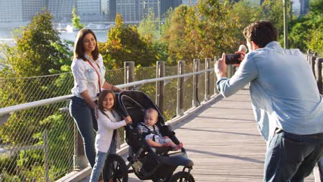 young family taking a photo on a footbridge in manhattan