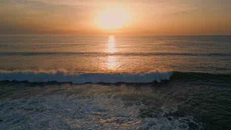 sunrise sea surf washing beach drone view. golden dawn sky ocean water surface