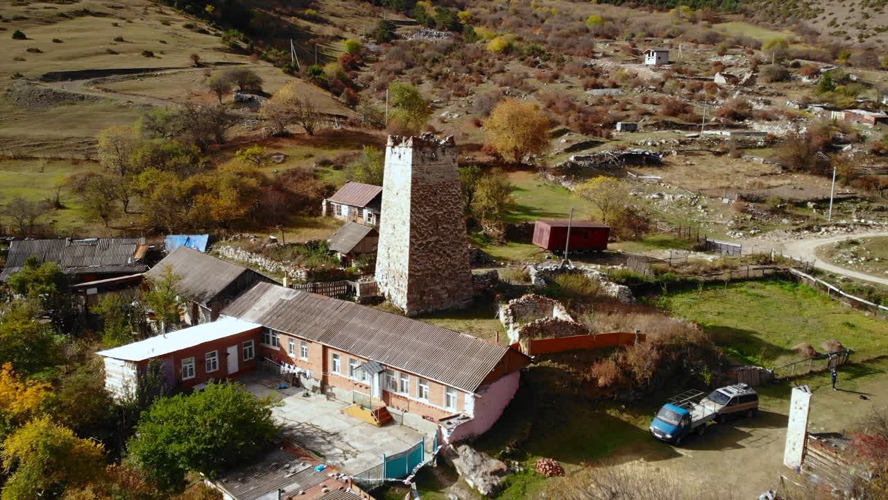 Village with Ancient Tower in Mountainous Landscape