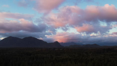 Vibrant-fluffy-sunset-clouds-over-ancient-temperate-rainforest-in-Tofino