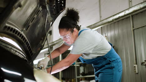 mujer reparando auto