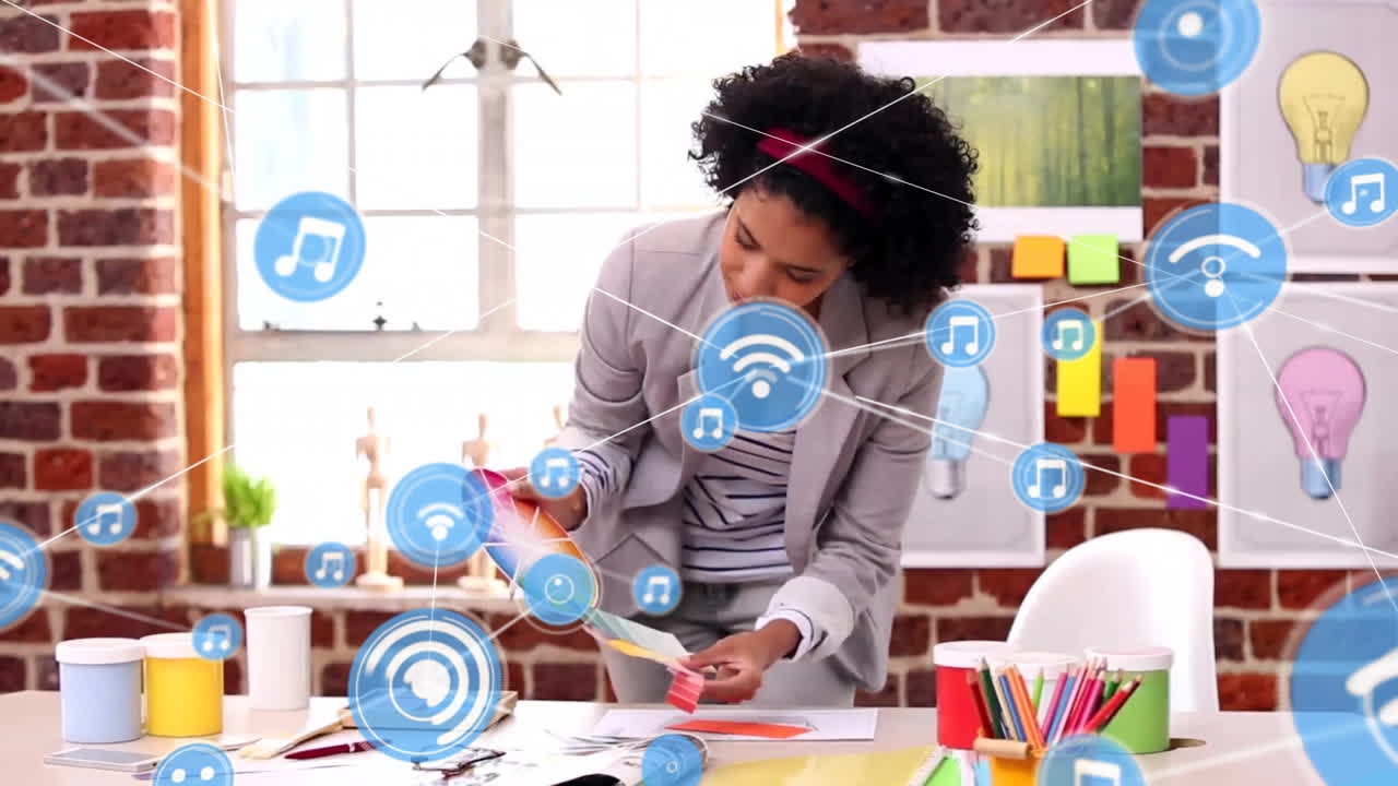 Animation of network of connections with icons over biracial businesswoman in office