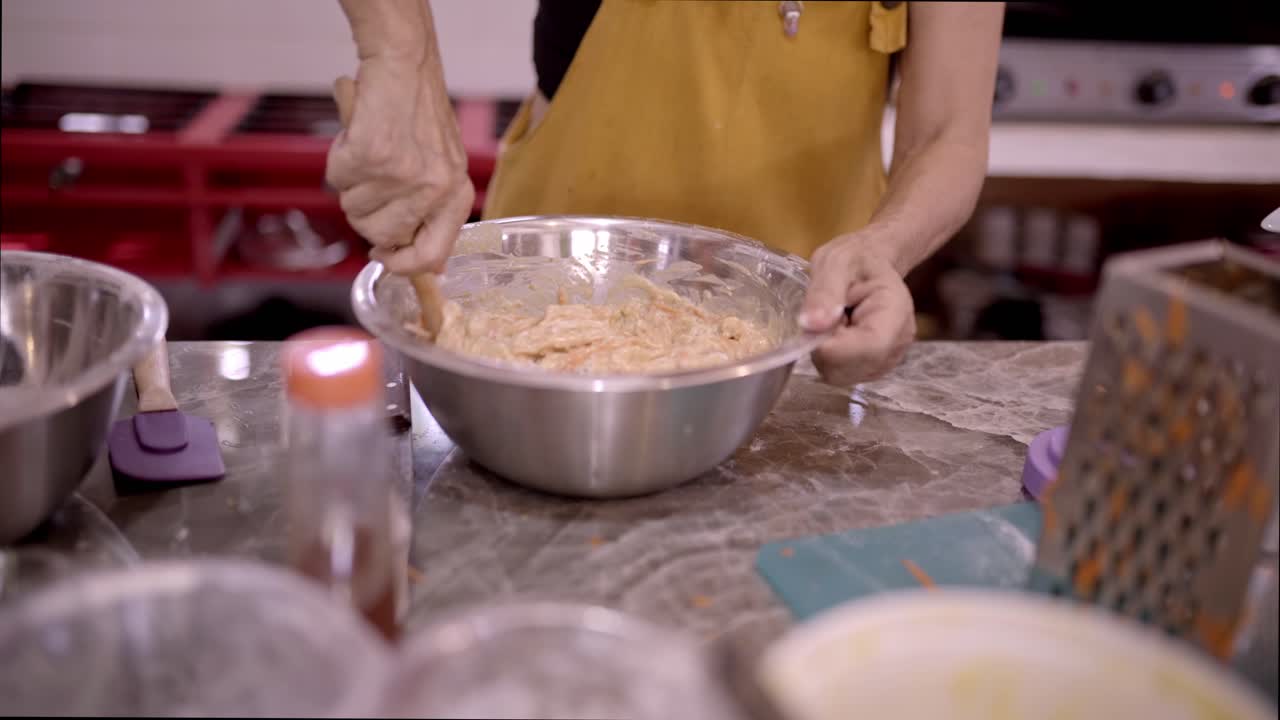 la mujer de la cosecha agitando la masa en el cuenco en la cocina