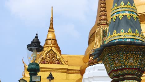 close-up of decorative spires and golden temple architecture against a clear blue sky.