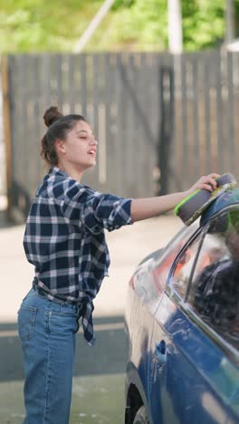 teenager washing a car at a self-service car wash