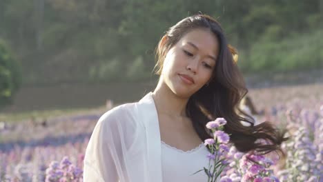 happy thai woman having fun in a flower field