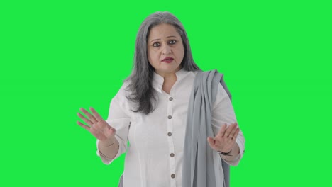 Serious-Indian-senior-businesswoman-talking-Green-screen