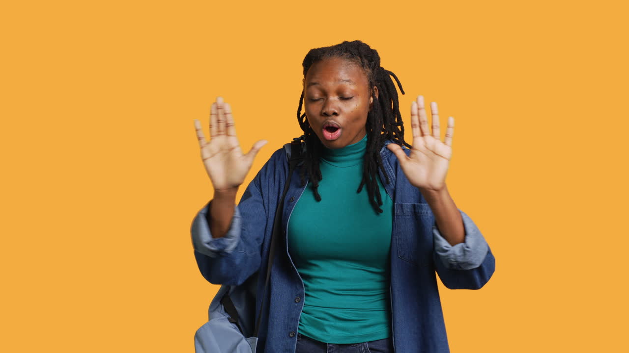 Assertive woman doing stop hand gesture, studio background