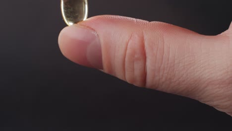 omega fish oil gel capsules on man hand close-up . human keeps in hands omega vitamins pills 3 6 9. to be healthy and take care of your health. pharmaceutical industry. business of biological supplements and vitamin.
