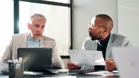 two businessmen in a meeting discussing documents