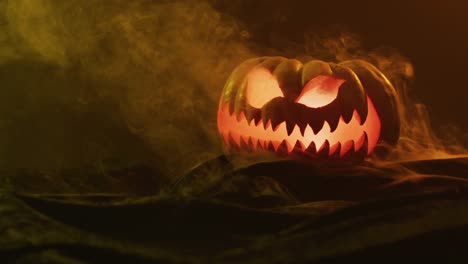 Video-Von-Geschnitztem-Halloween-Kürbis-Mit-Rauch-Und-Orangefarbenem-Licht-Auf-Schwarzem-Hintergrund