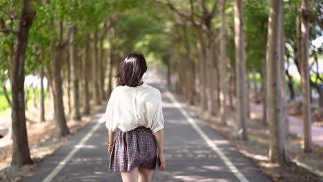 Woman-walking-along-bicycle-lane-in-park