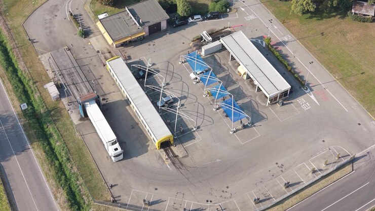 Aerial view of a specialized vehicle washing facility serving trucks, vans, cars and campers in Settala near Milan, Italy, illustrating commercial transport services and vehicle infrastructure.